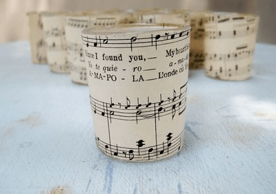 A candle holder made out of sheet music that says i found you