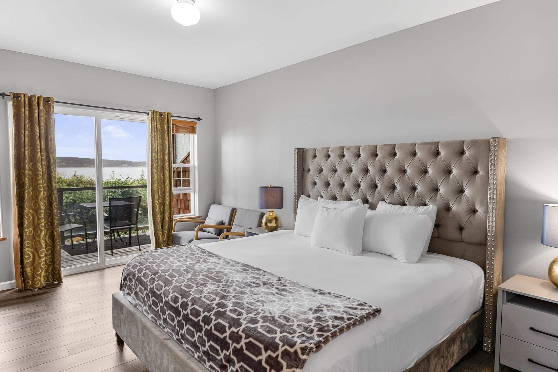 A hotel room with a king size bed and a balcony