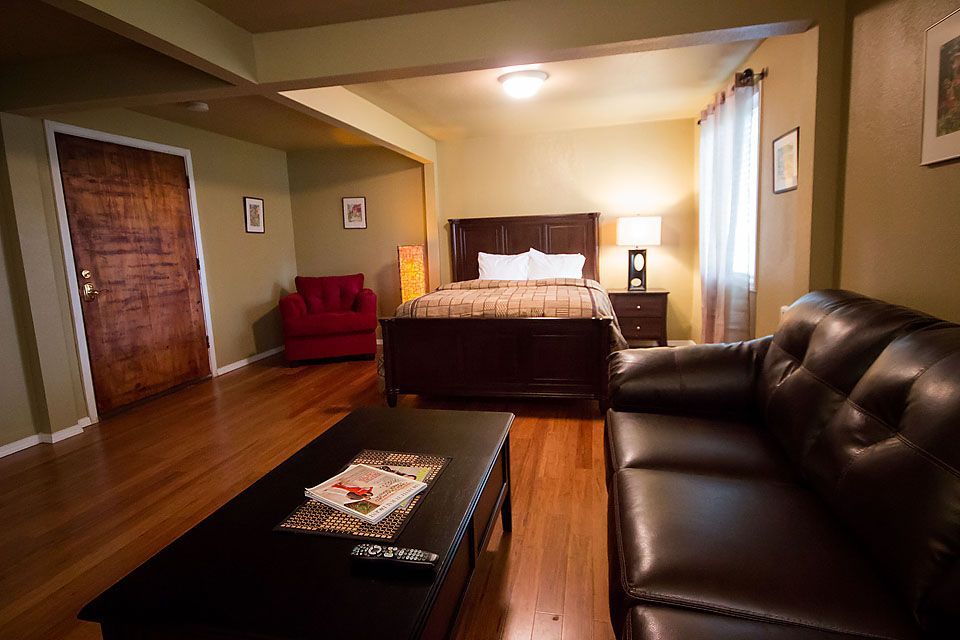 A living room with a couch , coffee table , and bed.