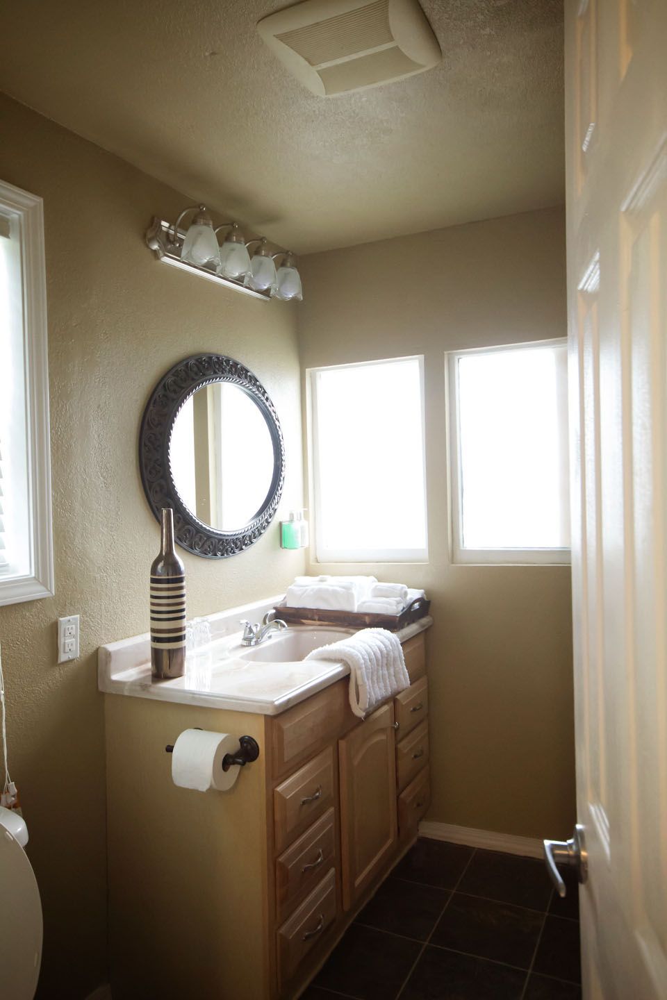 A bathroom with a sink a toilet and a mirror
