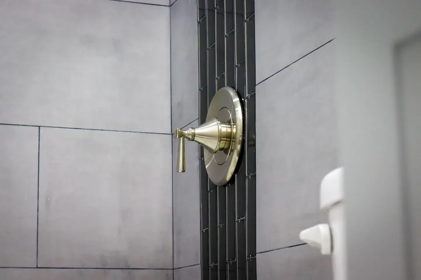 A close up of a shower head in a bathroom.