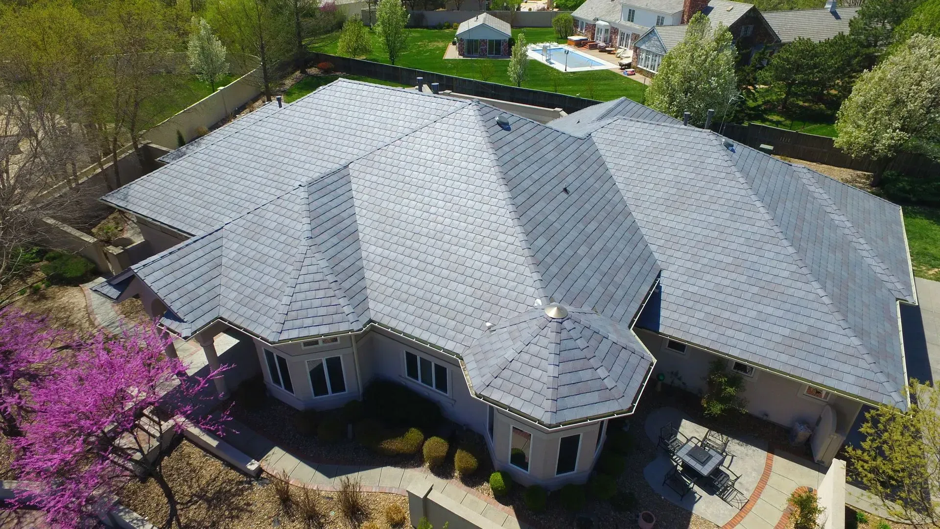An aerial view of a large house with a gray roof