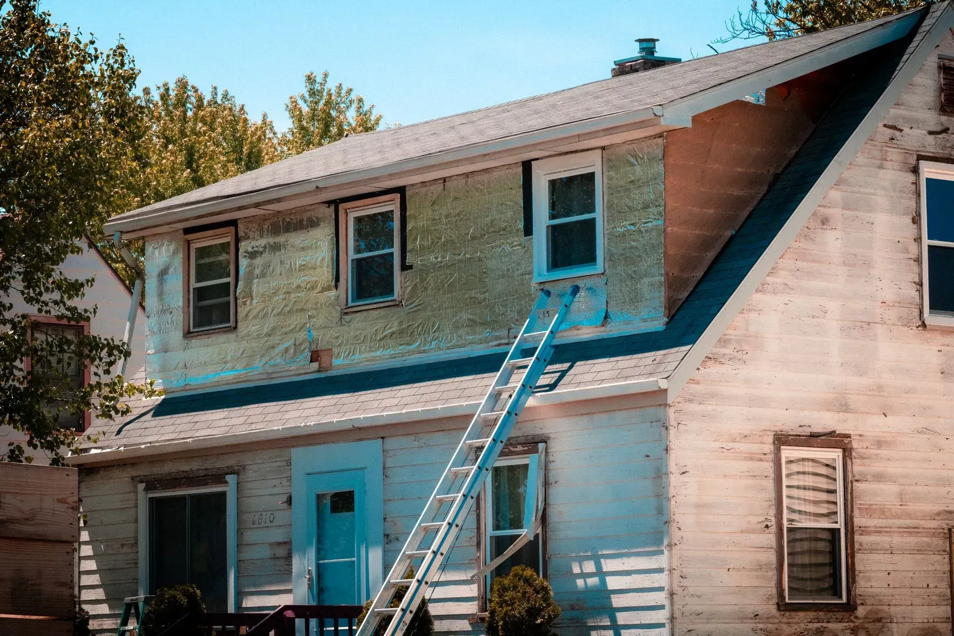 A ladder is sitting on the side of a house.