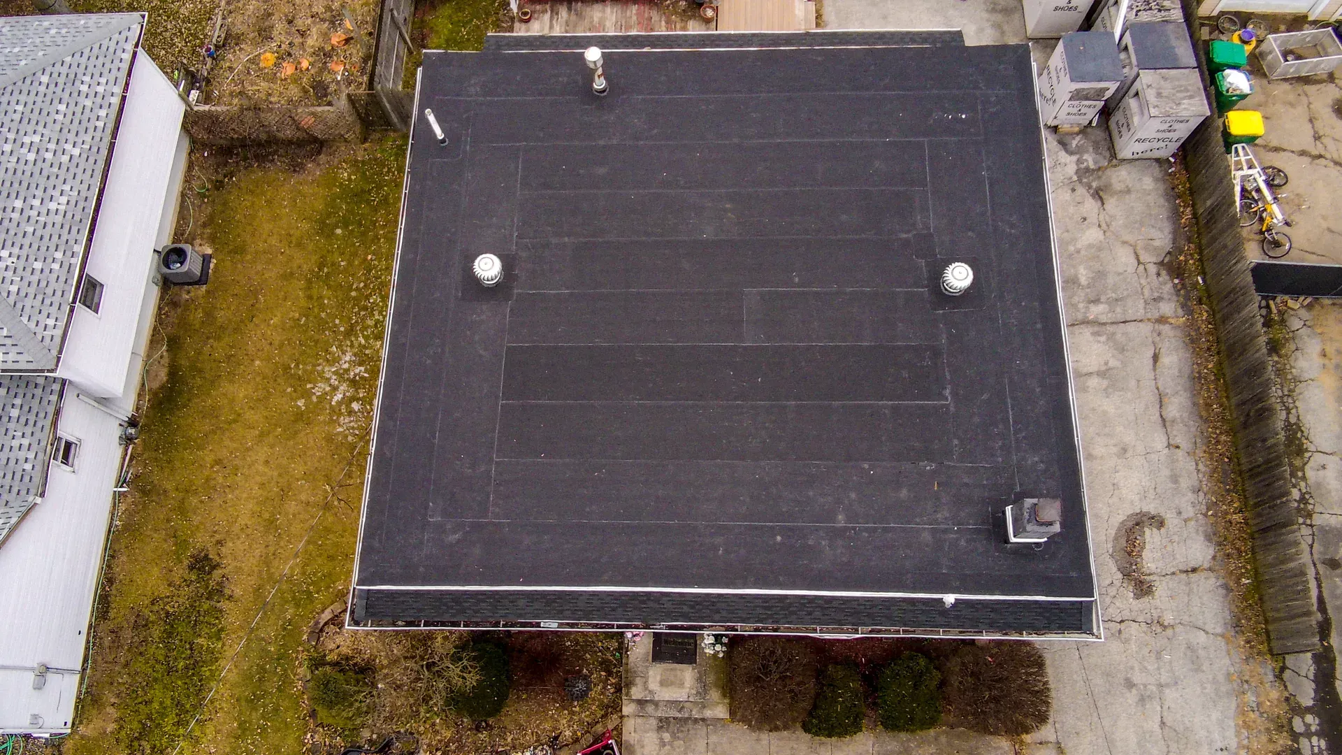 An aerial view of a roof of a house with a black roof.