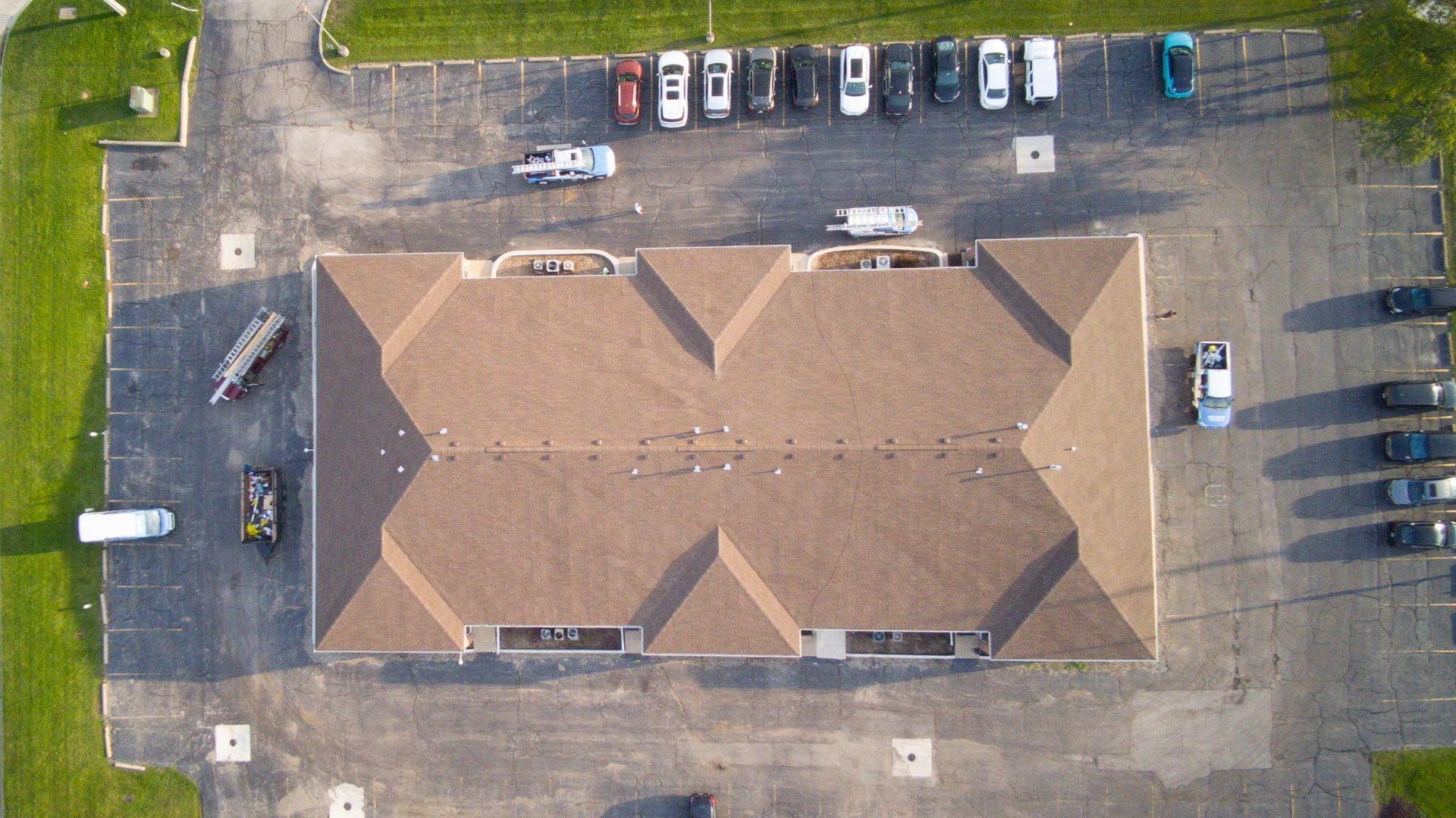An aerial view of a building with cars parked in front of it.