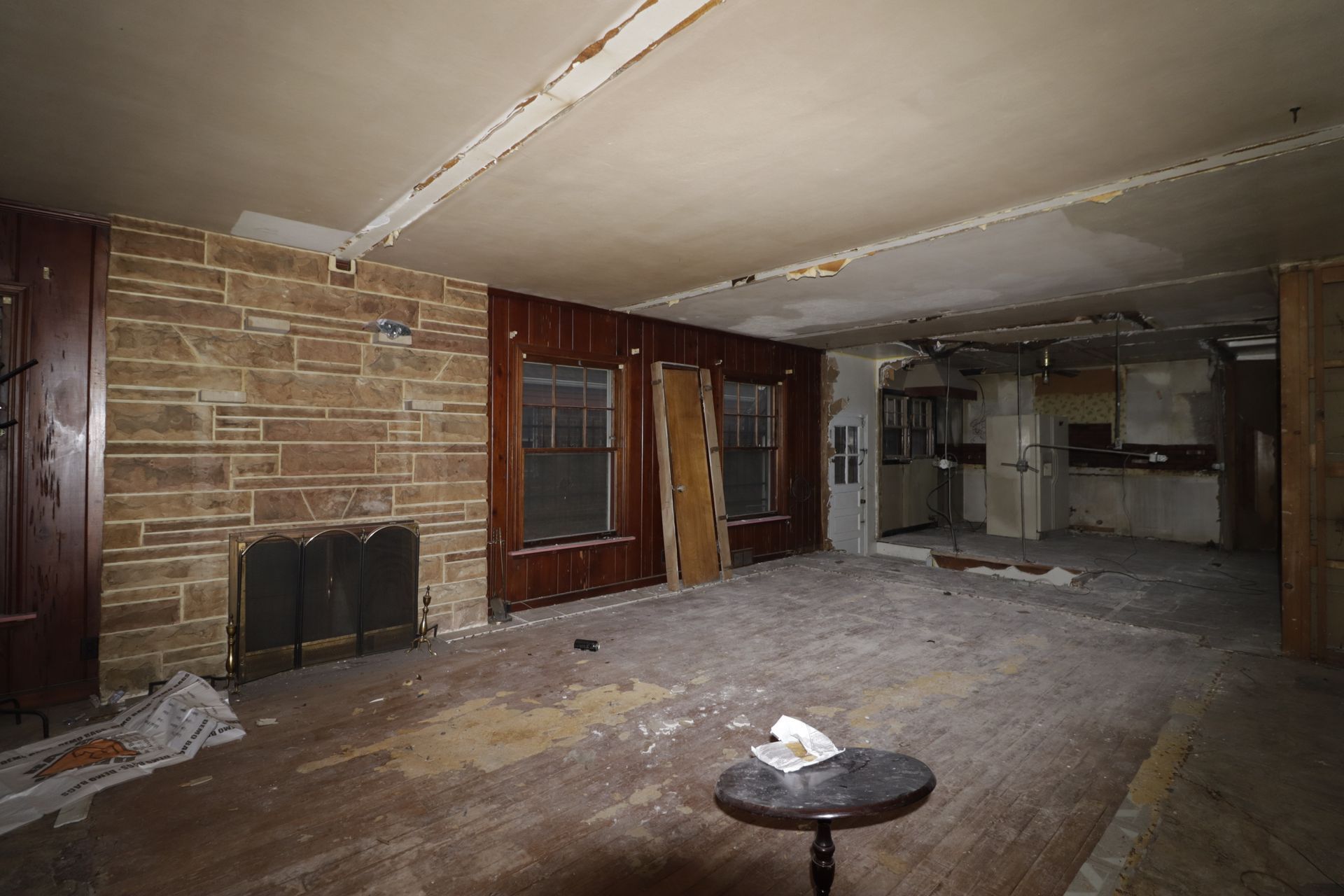 There is a table in the middle of the room in an abandoned house.