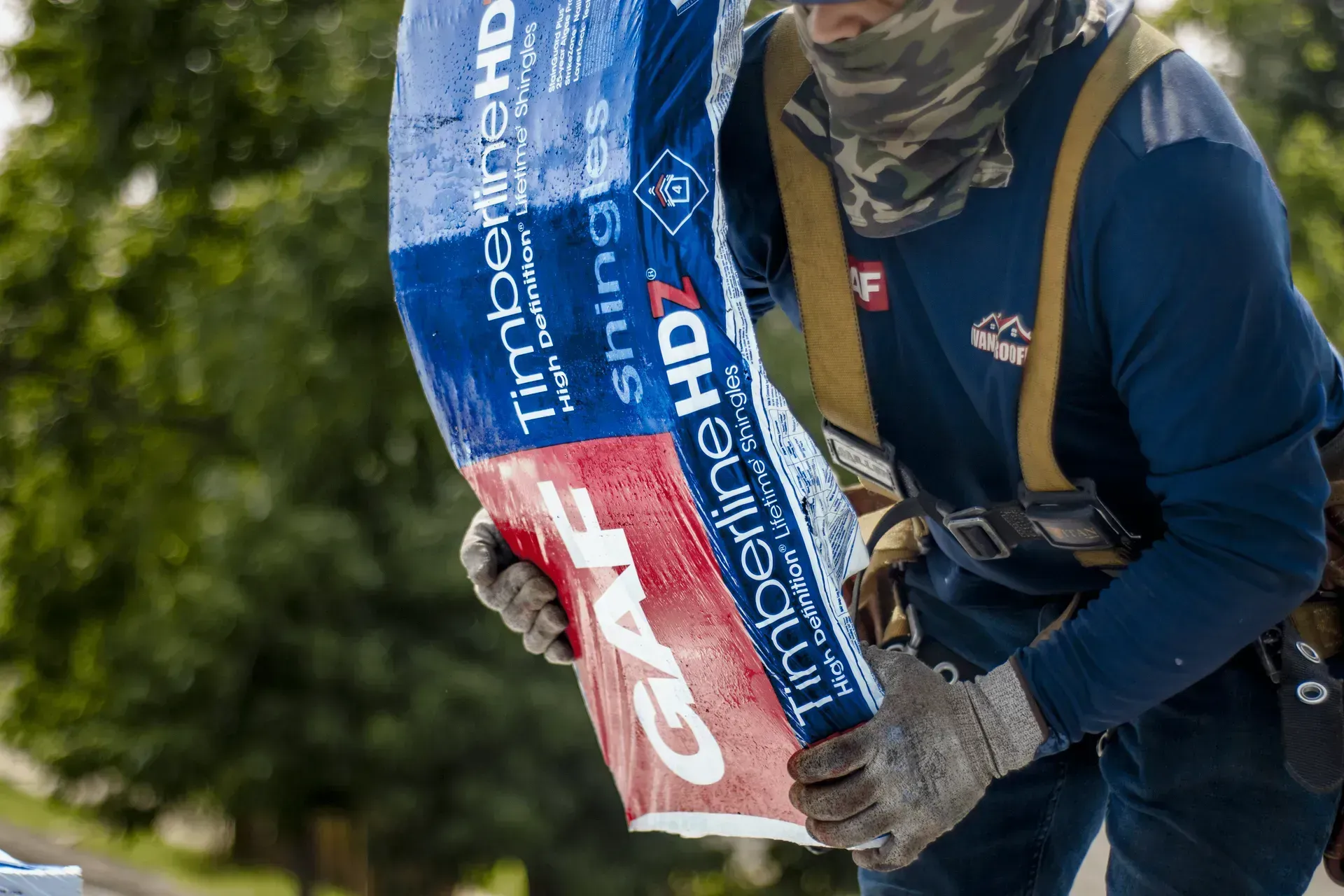 A man is carrying a large bag of lumber.