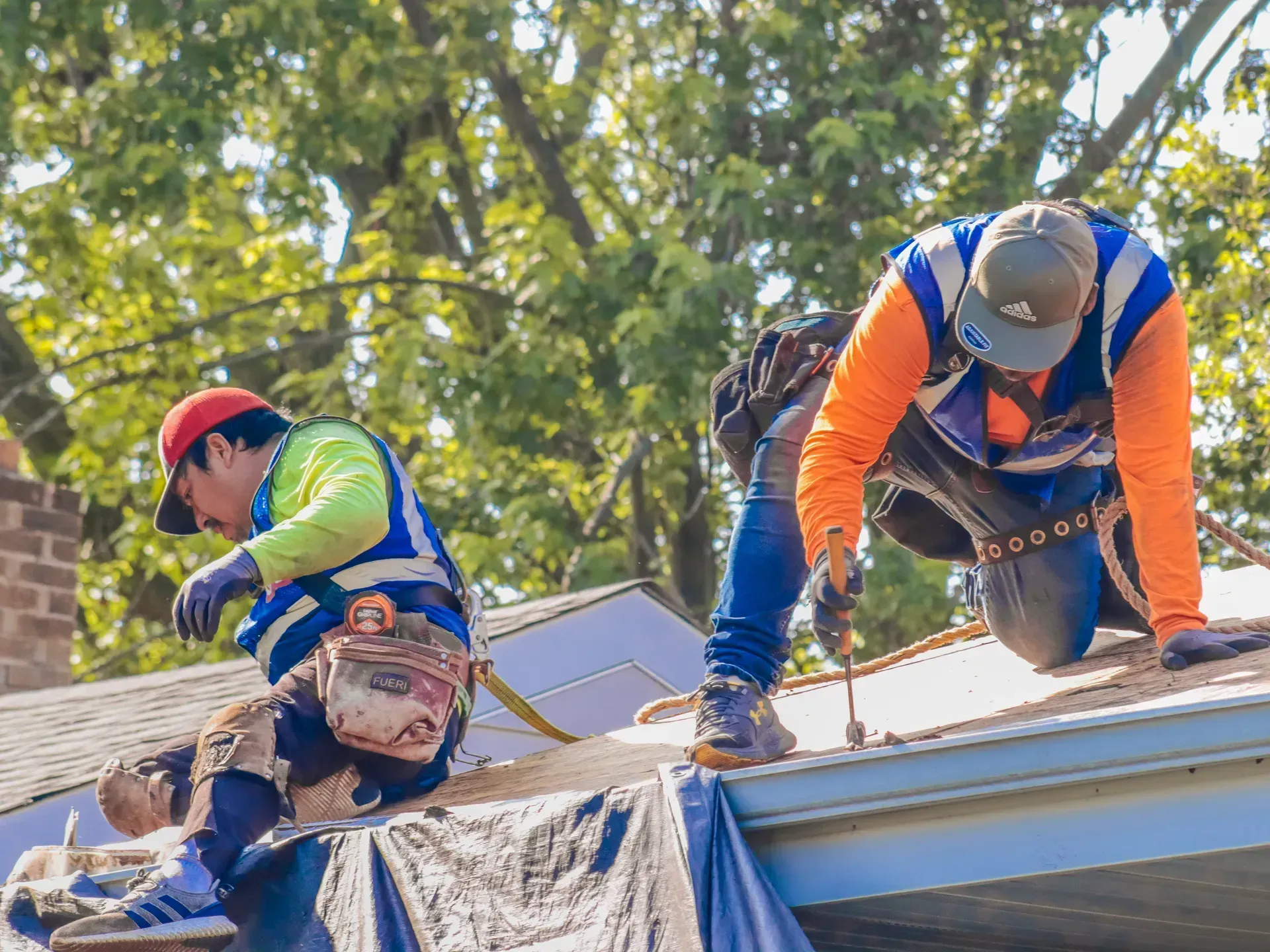 Two men are working on the roof of a house.