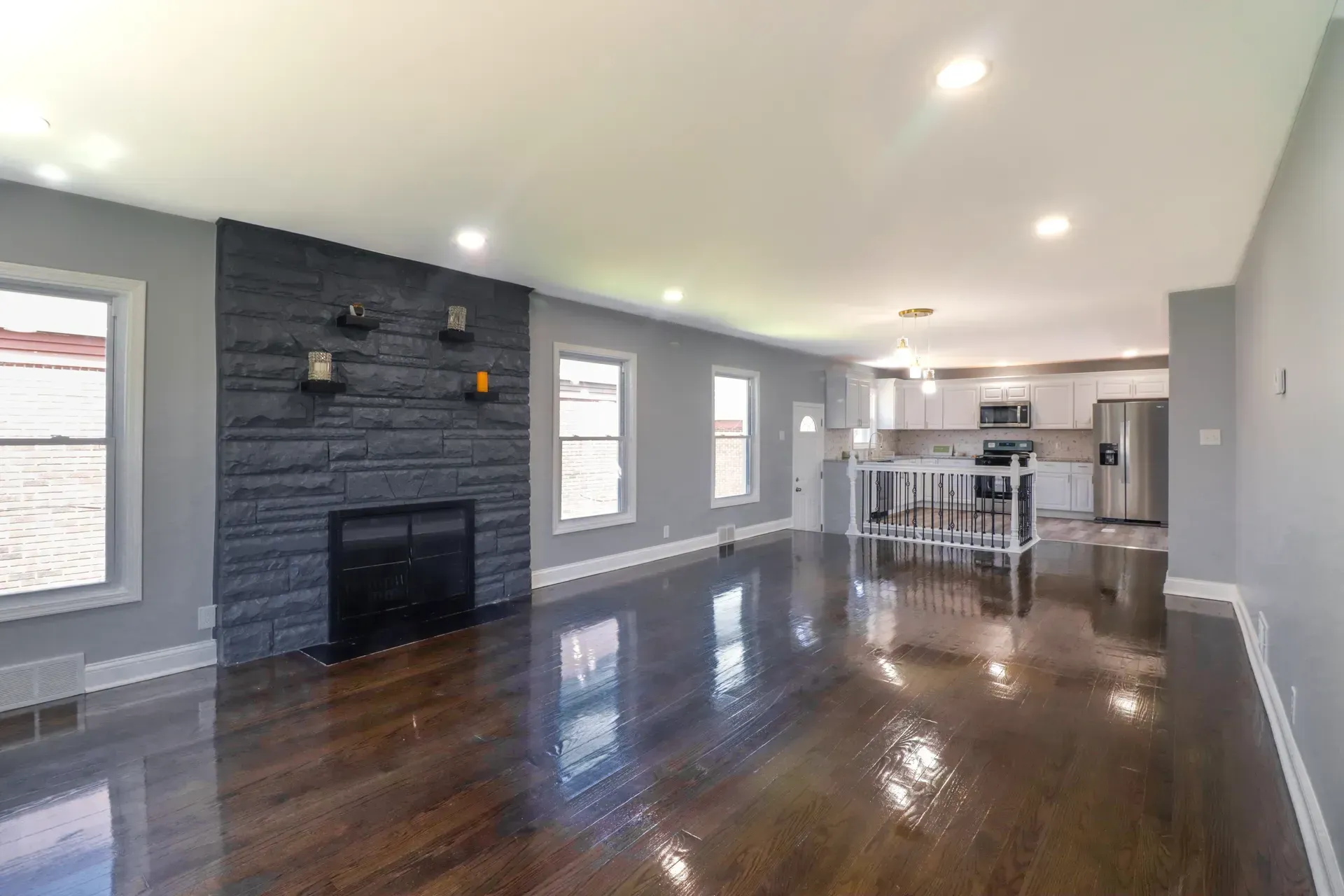 An empty living room with hardwood floors and a fireplace.