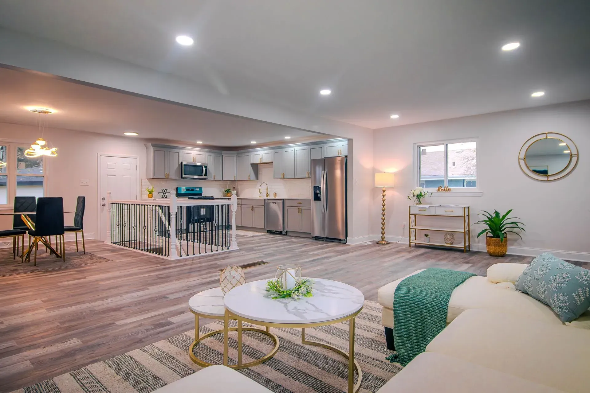 A living room with a couch, table and chairs and a kitchen in the background.