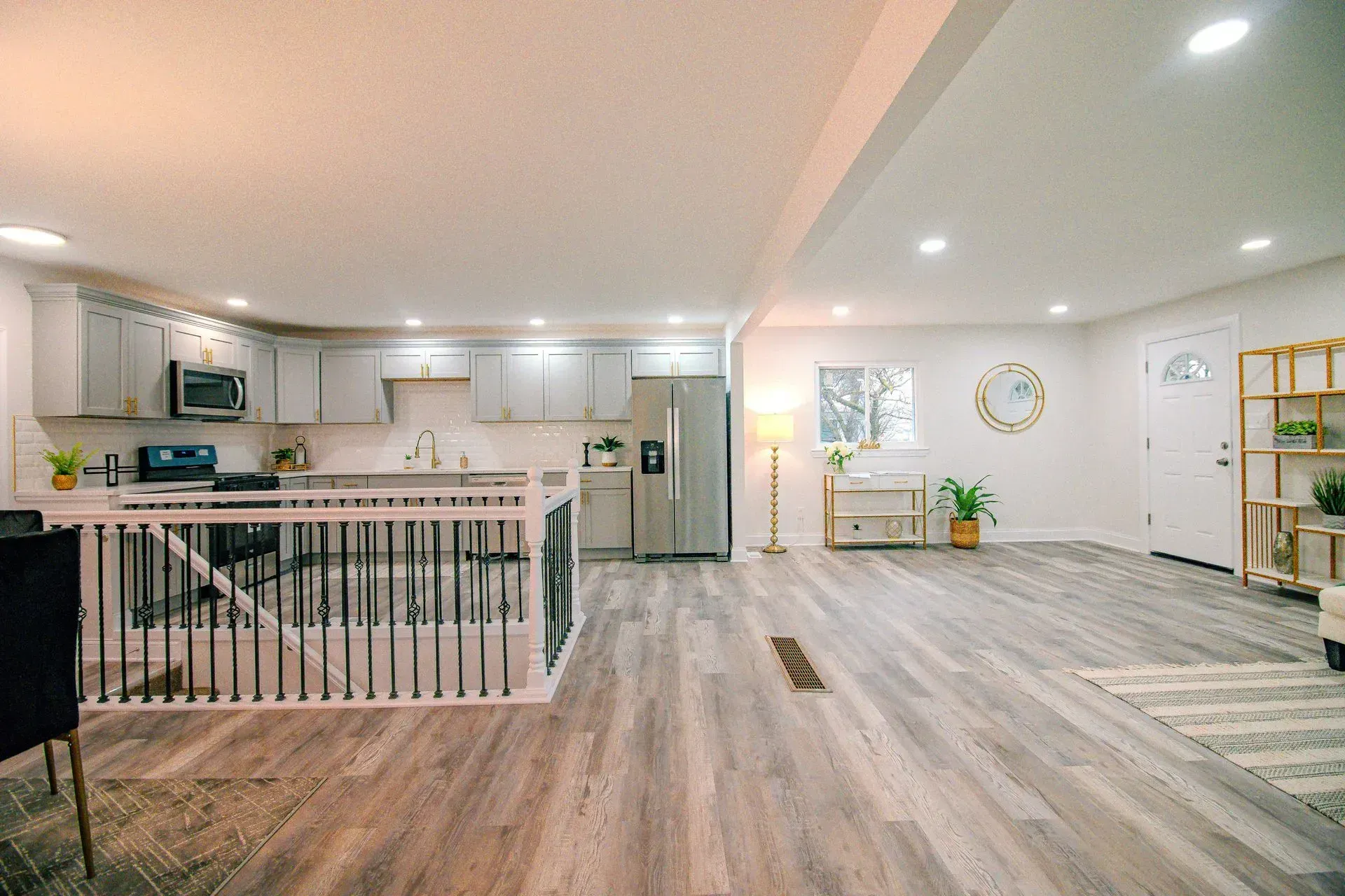A kitchen and living room in a house with hardwood floors.