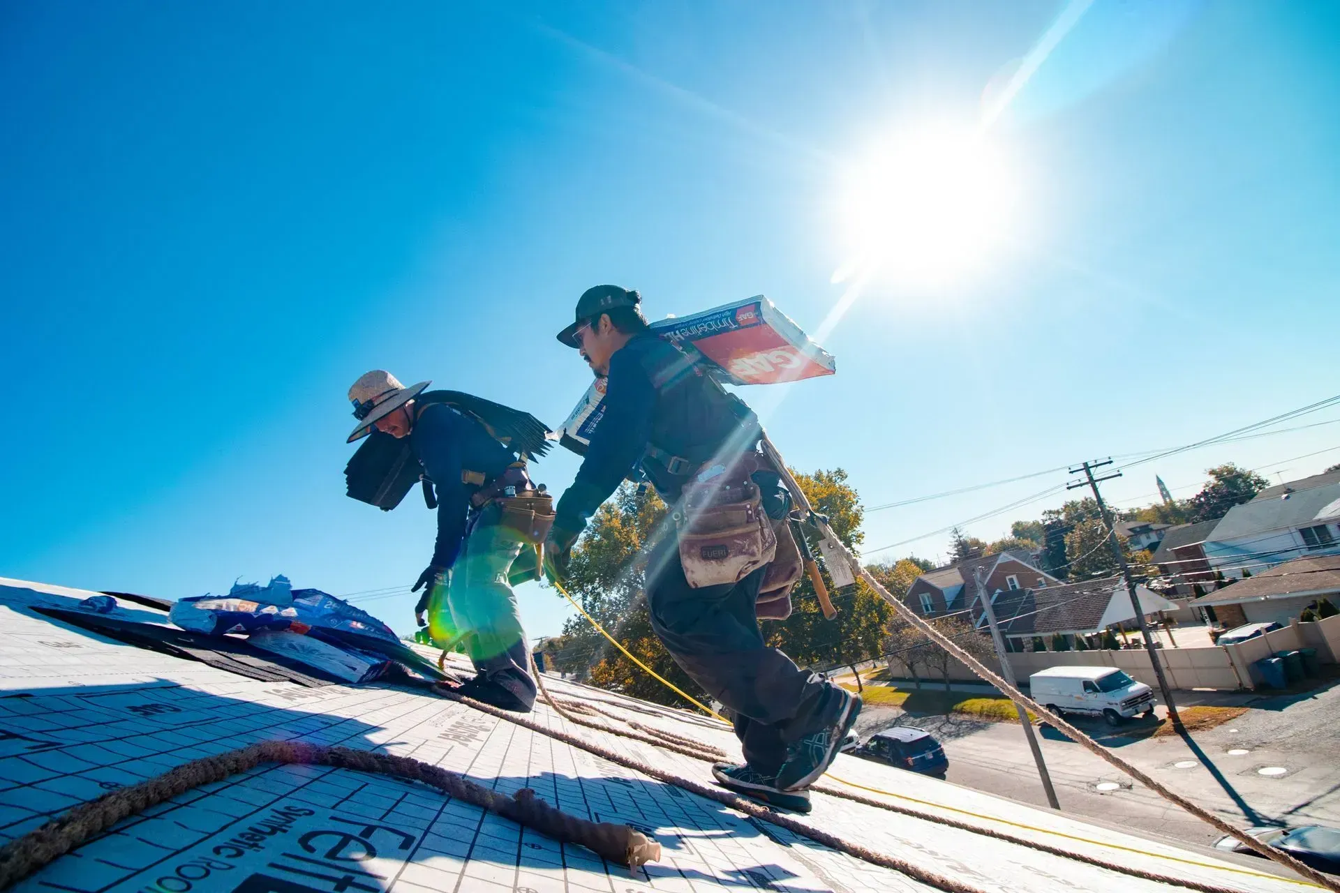 Two men are working on the roof of a house.