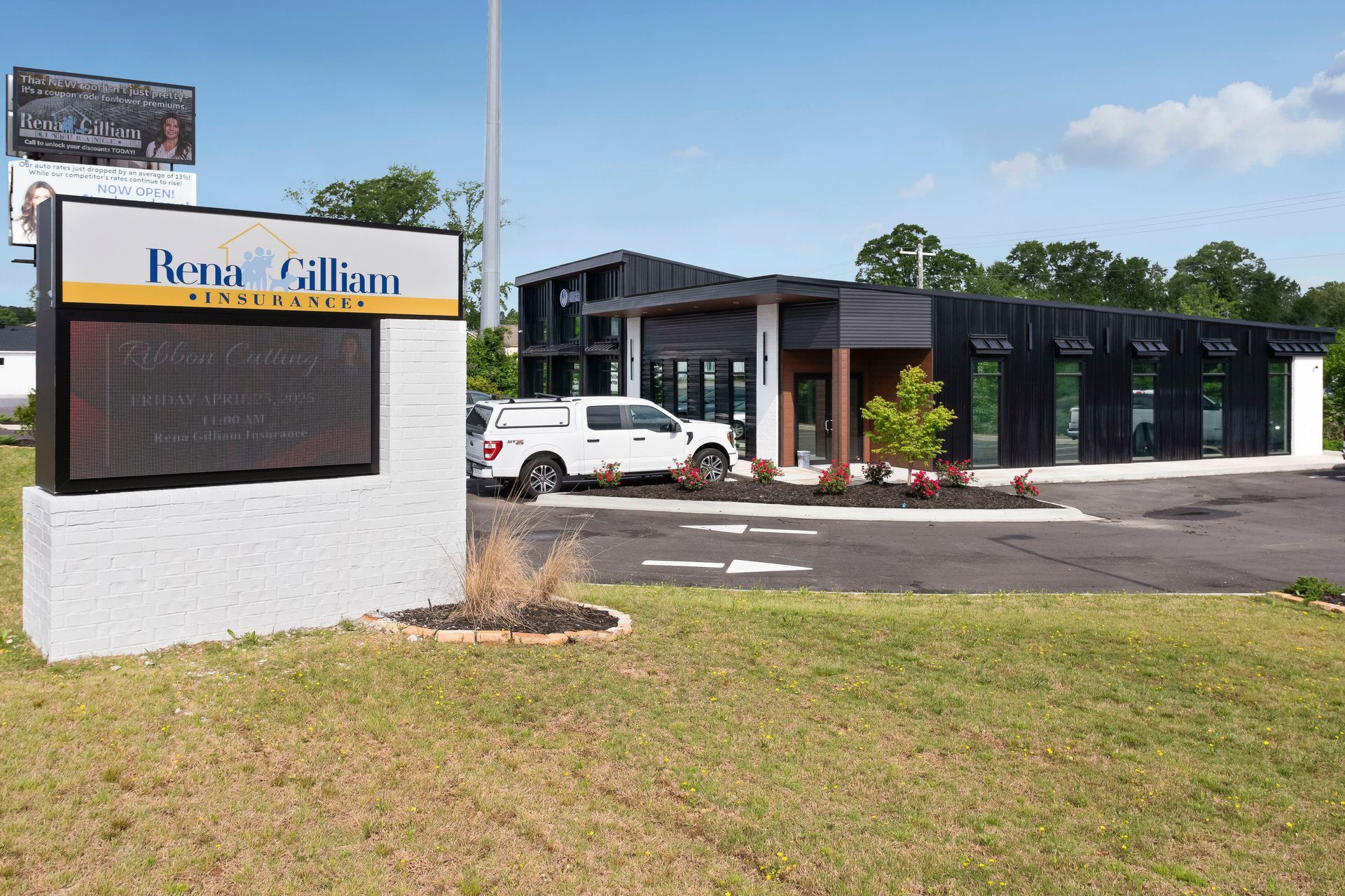 Rene Gilliam Insurance sign outside a black office building with a white truck parked in front of it. 