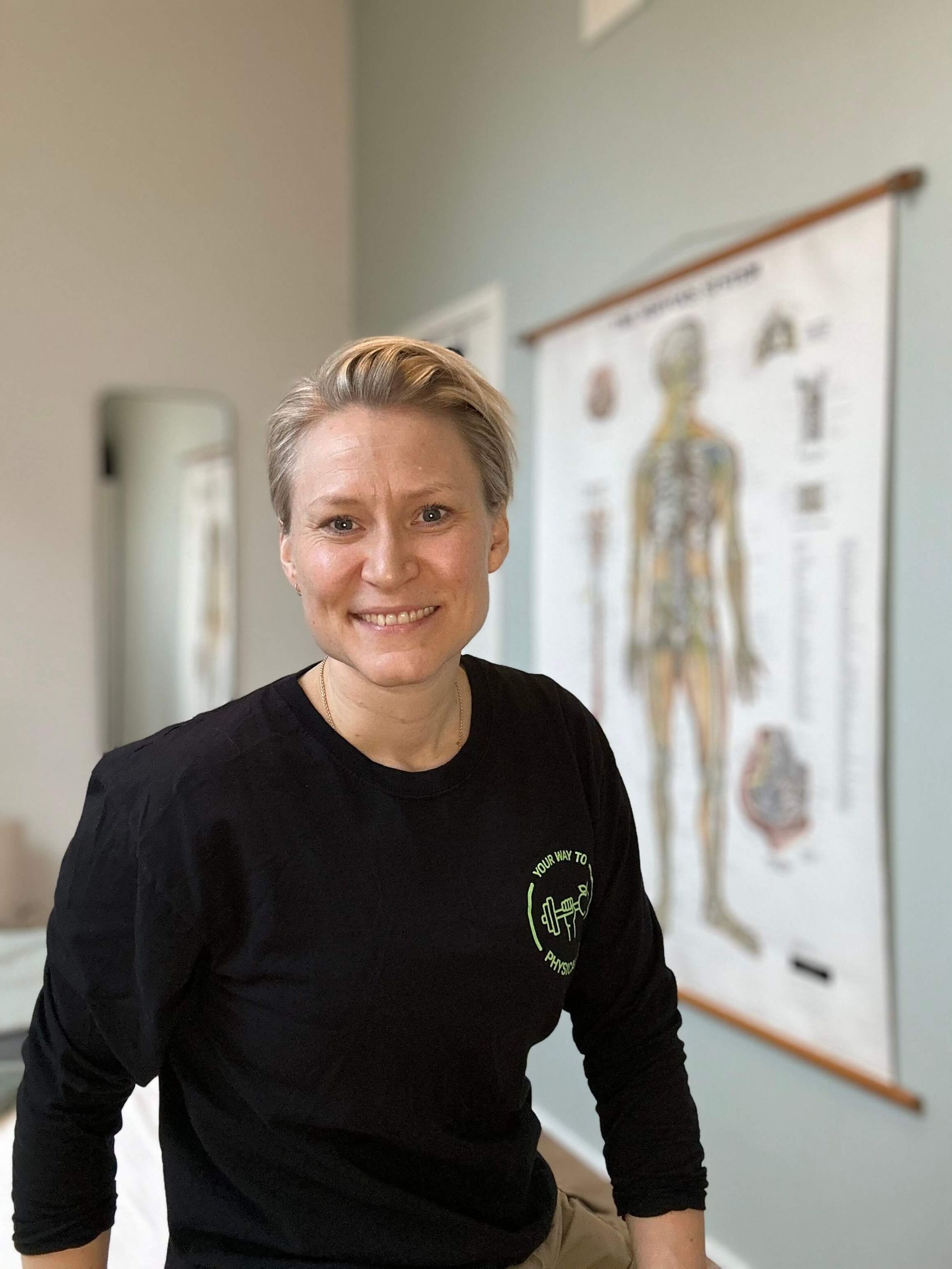 En kvinde i en sort skjorte smiler på et sort-hvidt foto.