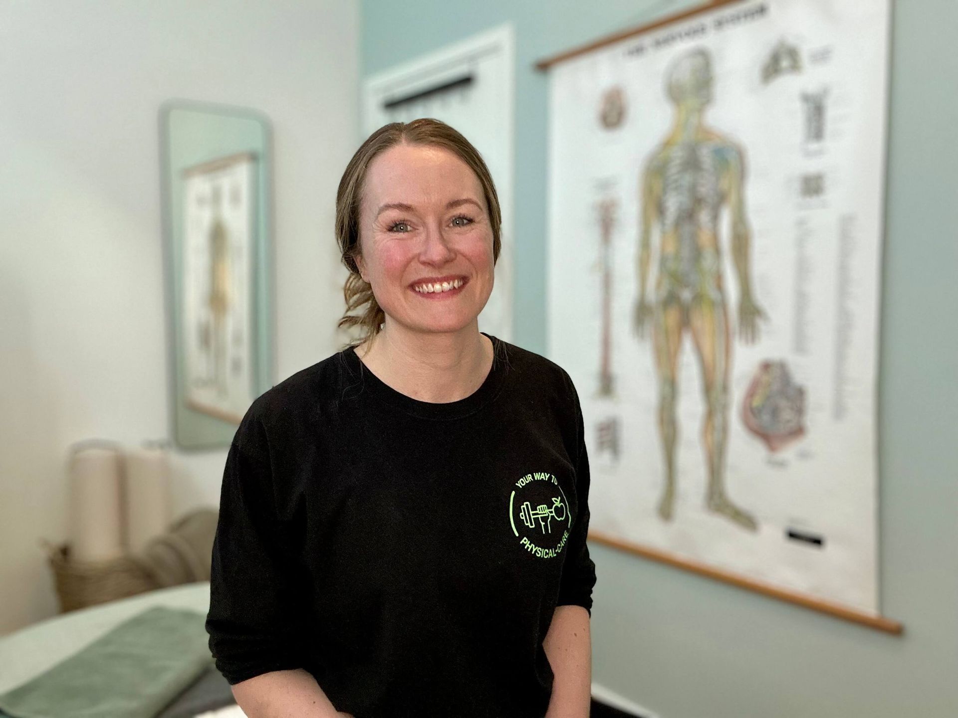 En kvinde i en blå skjorte smiler til kameraet.