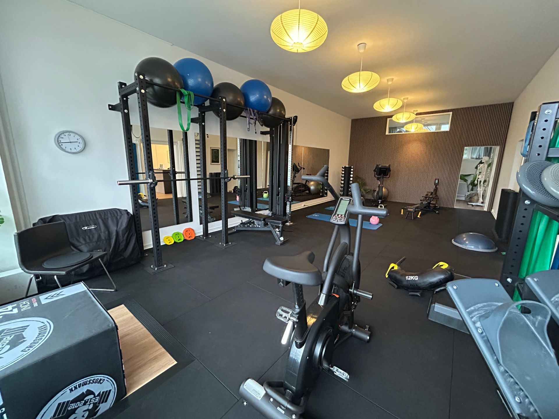 En gruppe kvinder laver øvelser med pilatesbolde i et fitnesscenter.