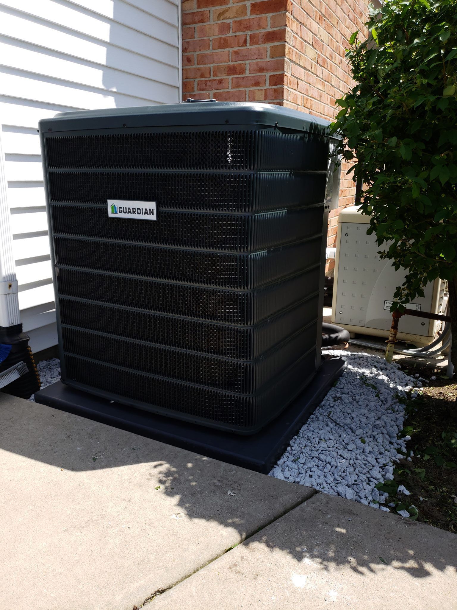 a black air conditioner is sitting on the side of a house .