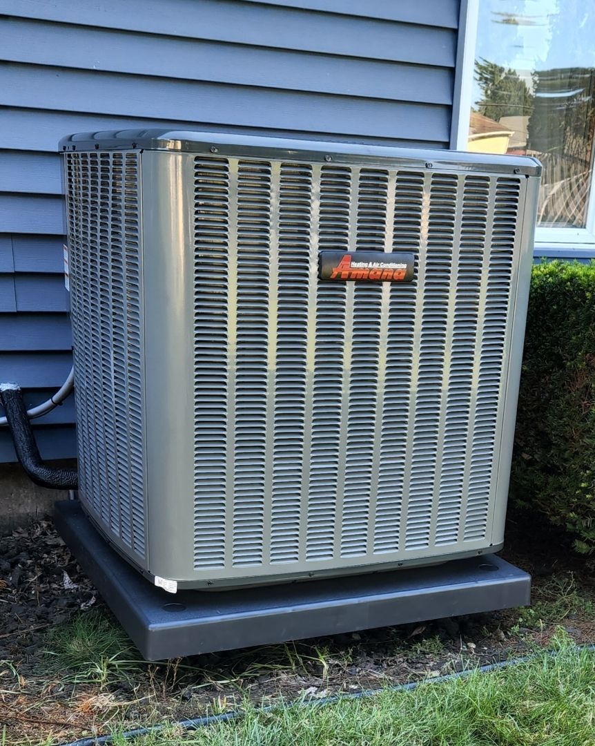 A large air conditioner is sitting outside of a house.
