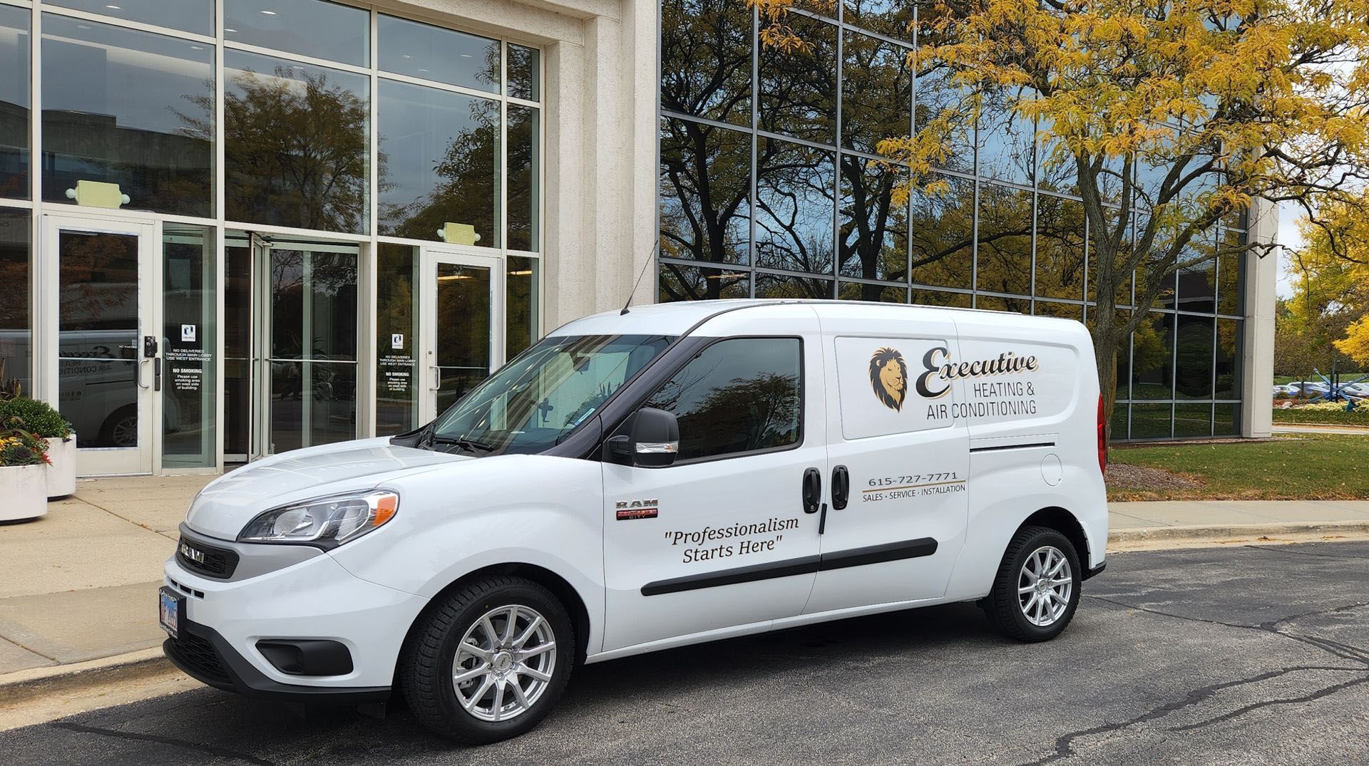 A white van is parked in front of a building.