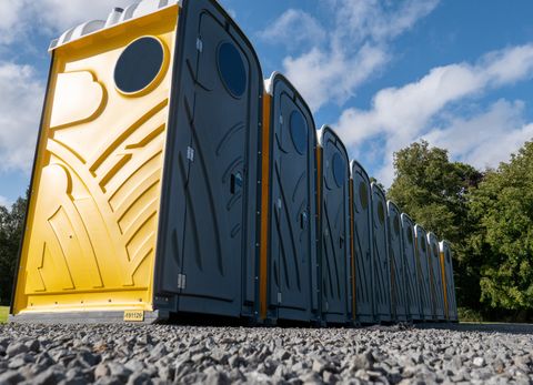 The front of a row of grey and yellow portable chemical toilets — Council Bluffs, IA — Norm's Pumping & Septic Services