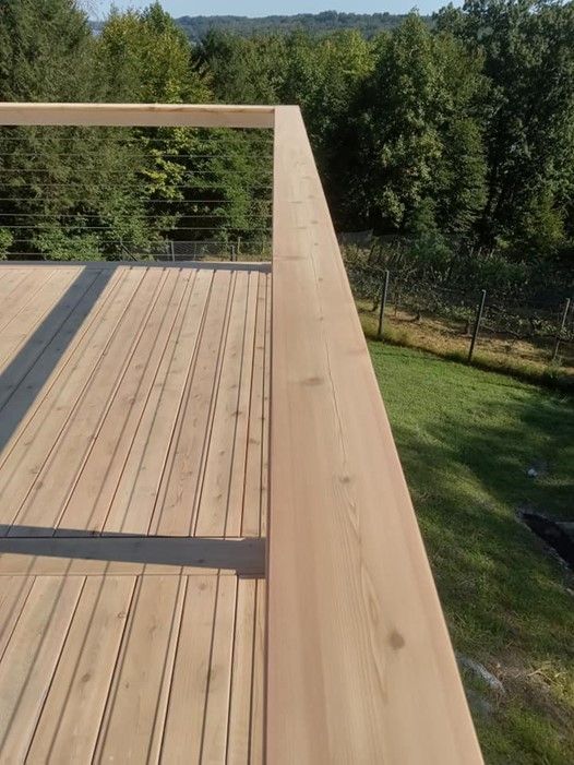 A Wooden Deck With A Metal Railing And Trees In The Background — Nyack, NY — FWS Home Improvement