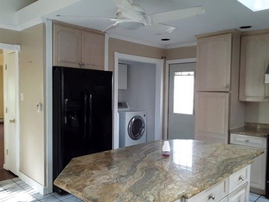 A Kitchen With A Large Island , A Refrigerator , A Washer And Dryer , And A Ceiling Fan — Nyack, NY — FWS Home Improvement