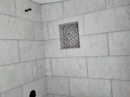A Bathroom With White Tiles And A Shower Head — Nyack, NY — FWS Home Improvement