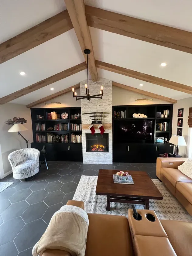 A living room with a couch, chair, coffee table and fireplace.