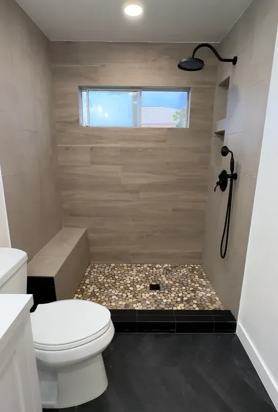 A bathroom with a toilet and a walk in shower
