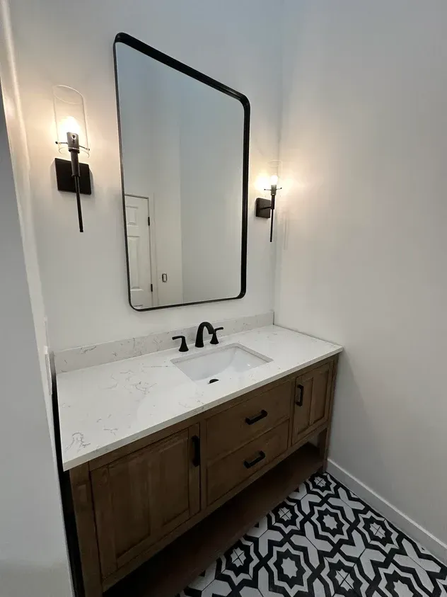 A bathroom with a sink, mirror and rug.