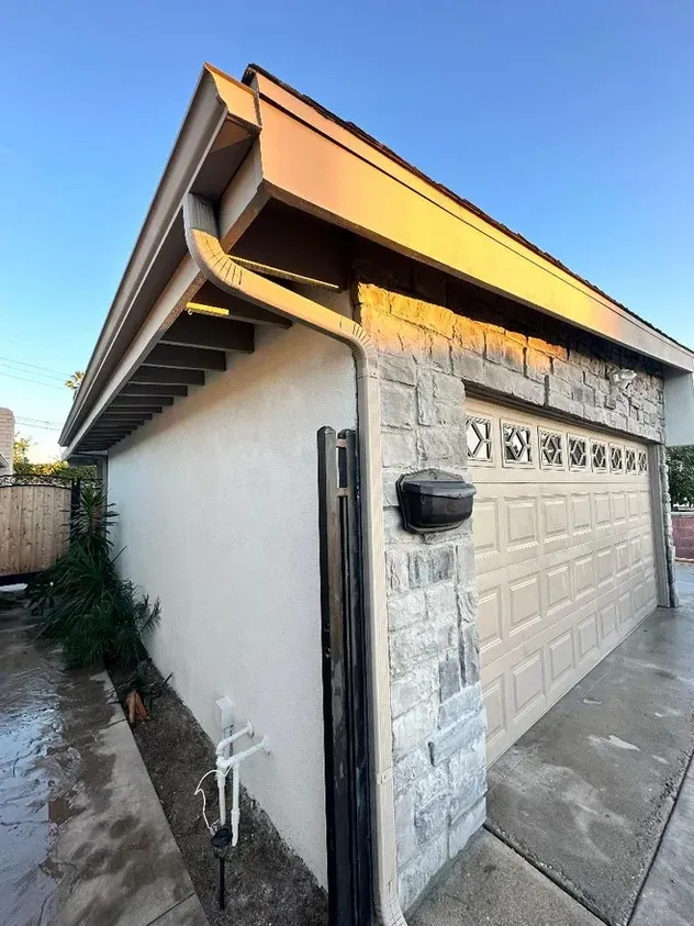 A garage with a roof and a mailbox on the side of it.