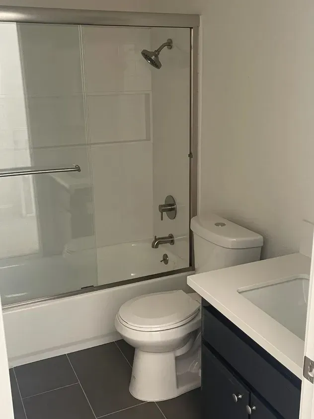 A bathroom with a toilet, sink, bathtub and shower.