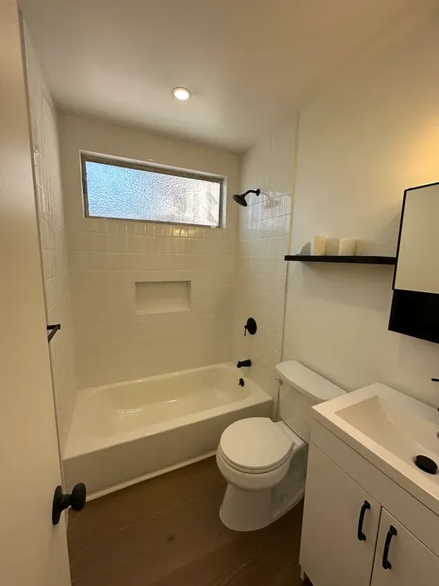 A bathroom with a toilet, sink, bathtub and shower.