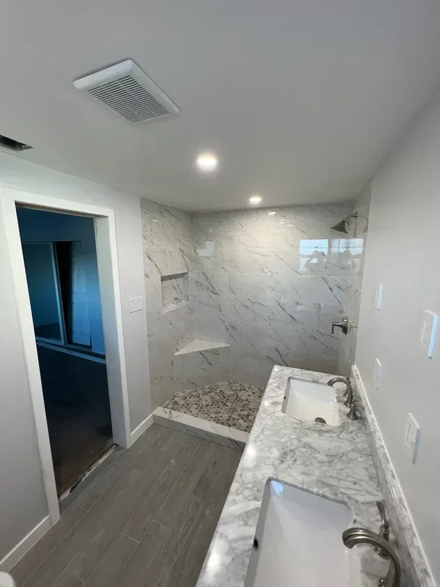 A bathroom with a sink and a walk in shower.