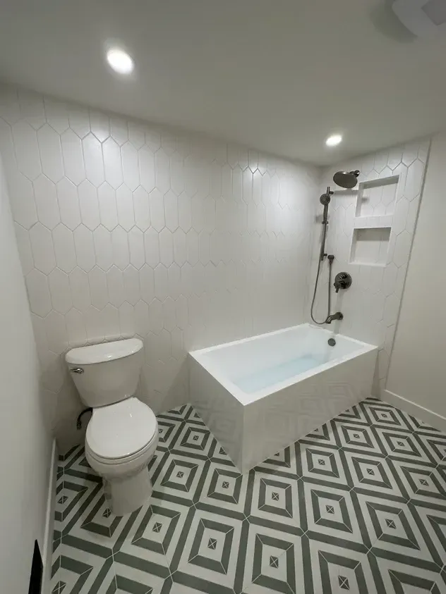 A bathroom with a toilet , bathtub and shower.
