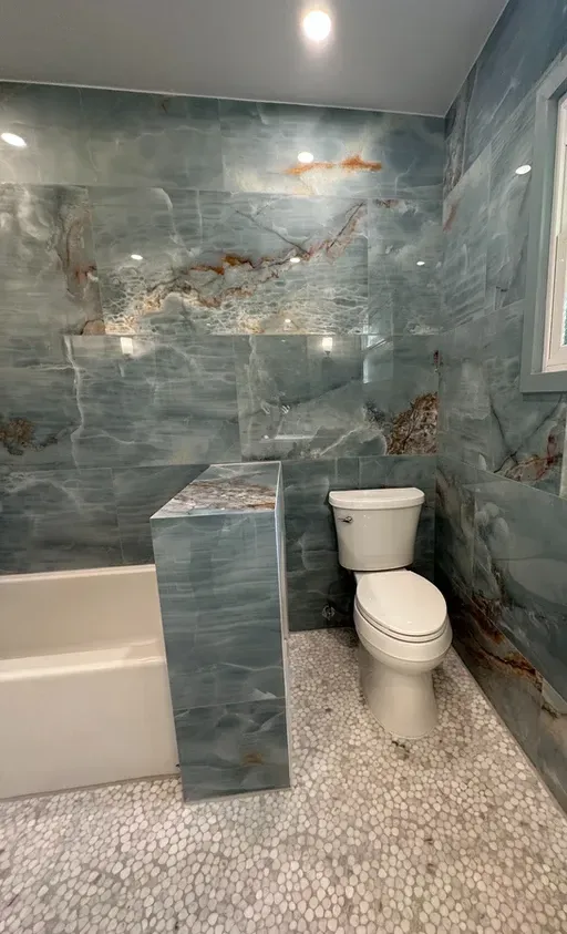 A bathroom with a toilet, tub and shower.