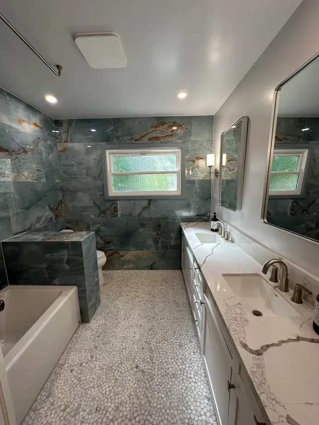 A bathroom with two sinks, a tub, and a mirror.