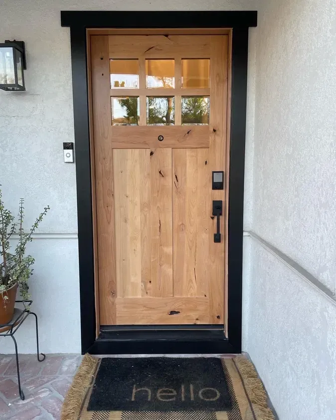 A wooden door with a hello mat in front of it