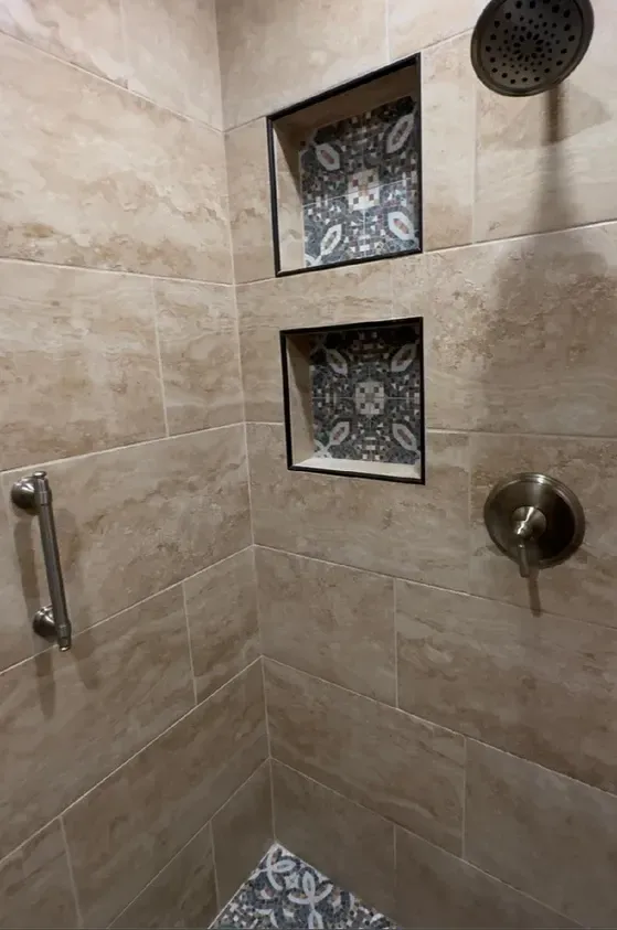 A shower with a hand rail and a shower head.