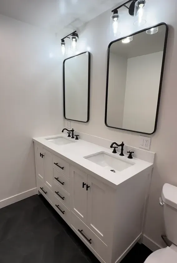A bathroom with two sinks and two mirrors.