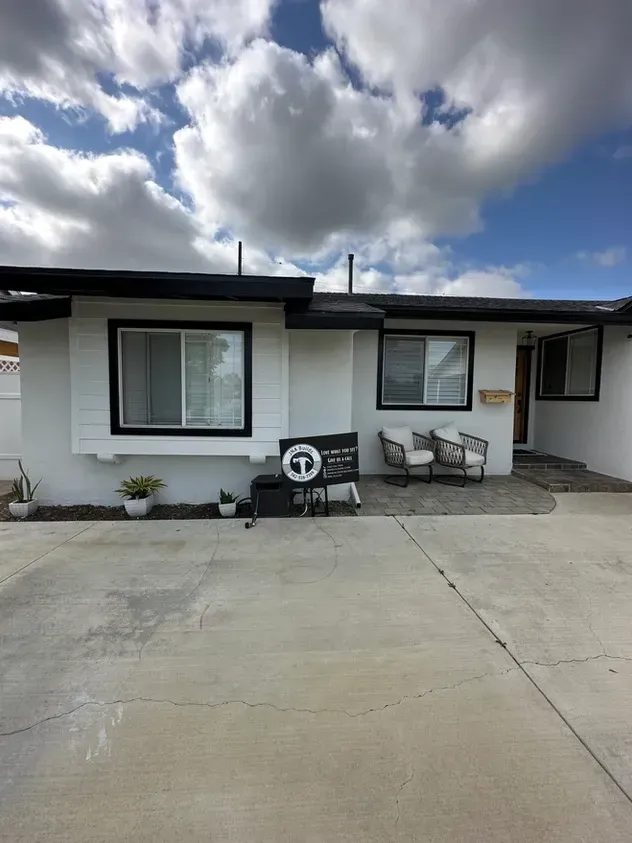 A white house with a sign that says t on it