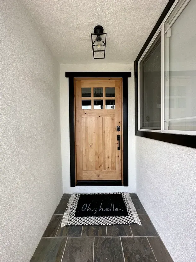 A doorway with a door mat that says oh hello