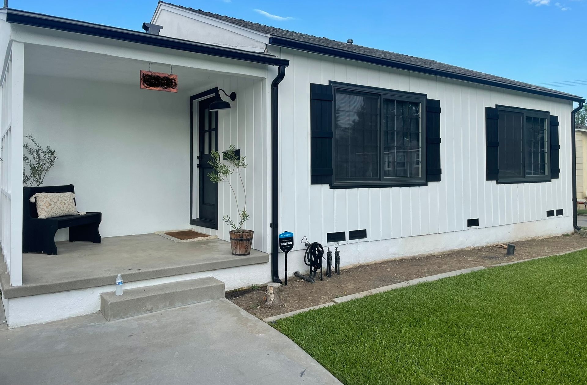 A white house with black shutters and a porch.