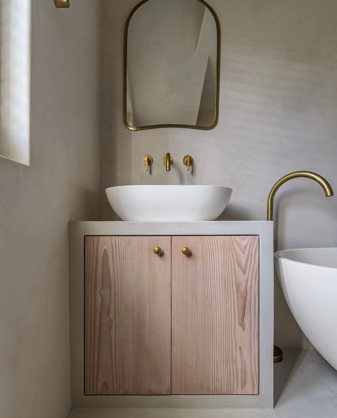 A bathroom with a sink , mirror and bathtub.