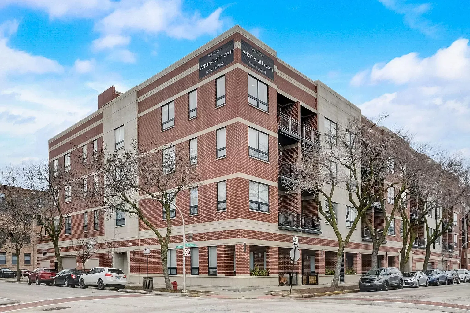 a large brick building with cars parked in front of it .