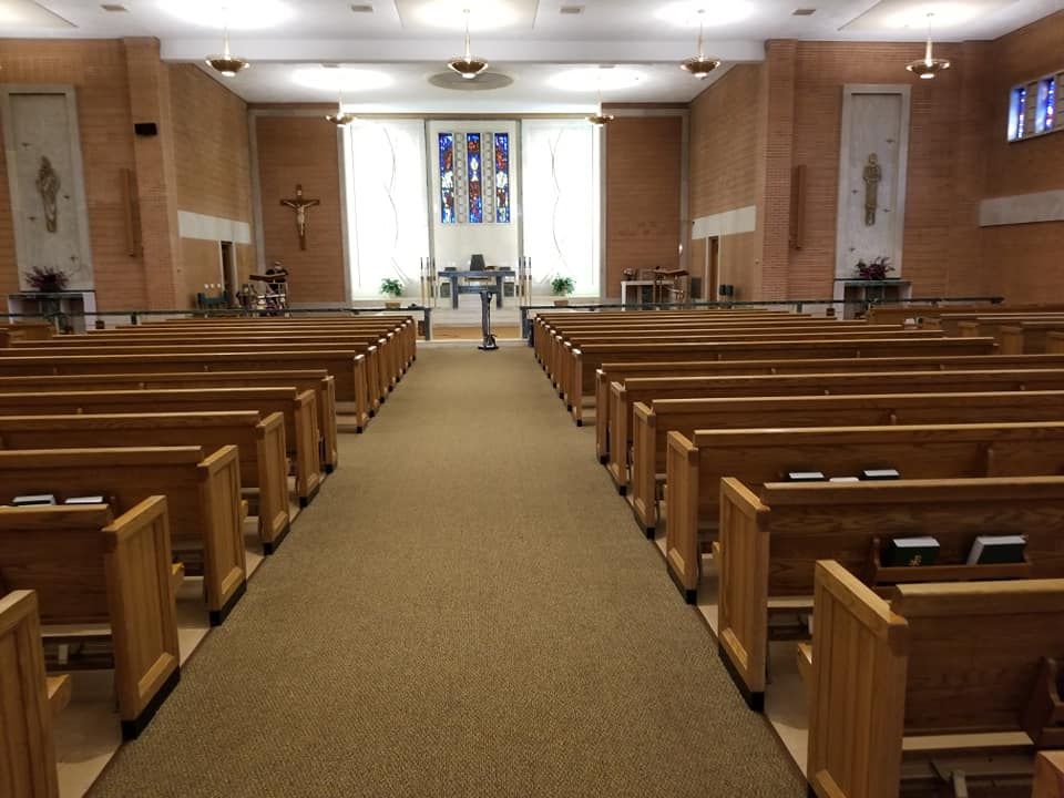 The inside of a church with rows of wooden benches