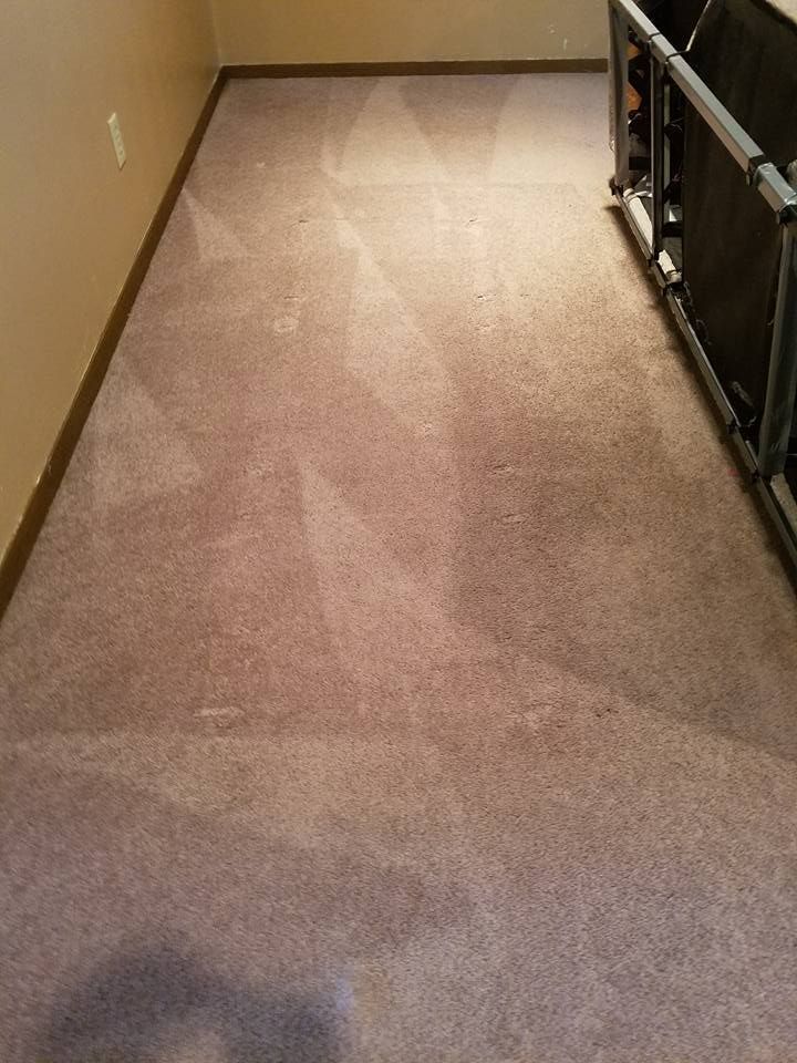 A room with a carpeted floor and a railing.