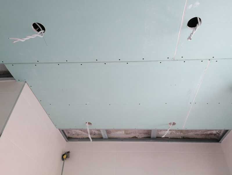 Decke im Bau mit Trockenbau, Elektroverkabelung und Einbauleuchten, hellgrüner Trockenbau.