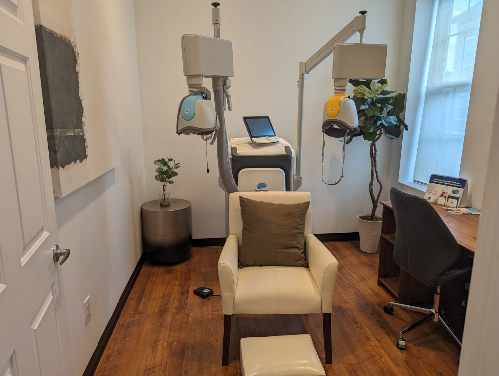 Man and woman smiling by dental X-ray machine in a bright room.