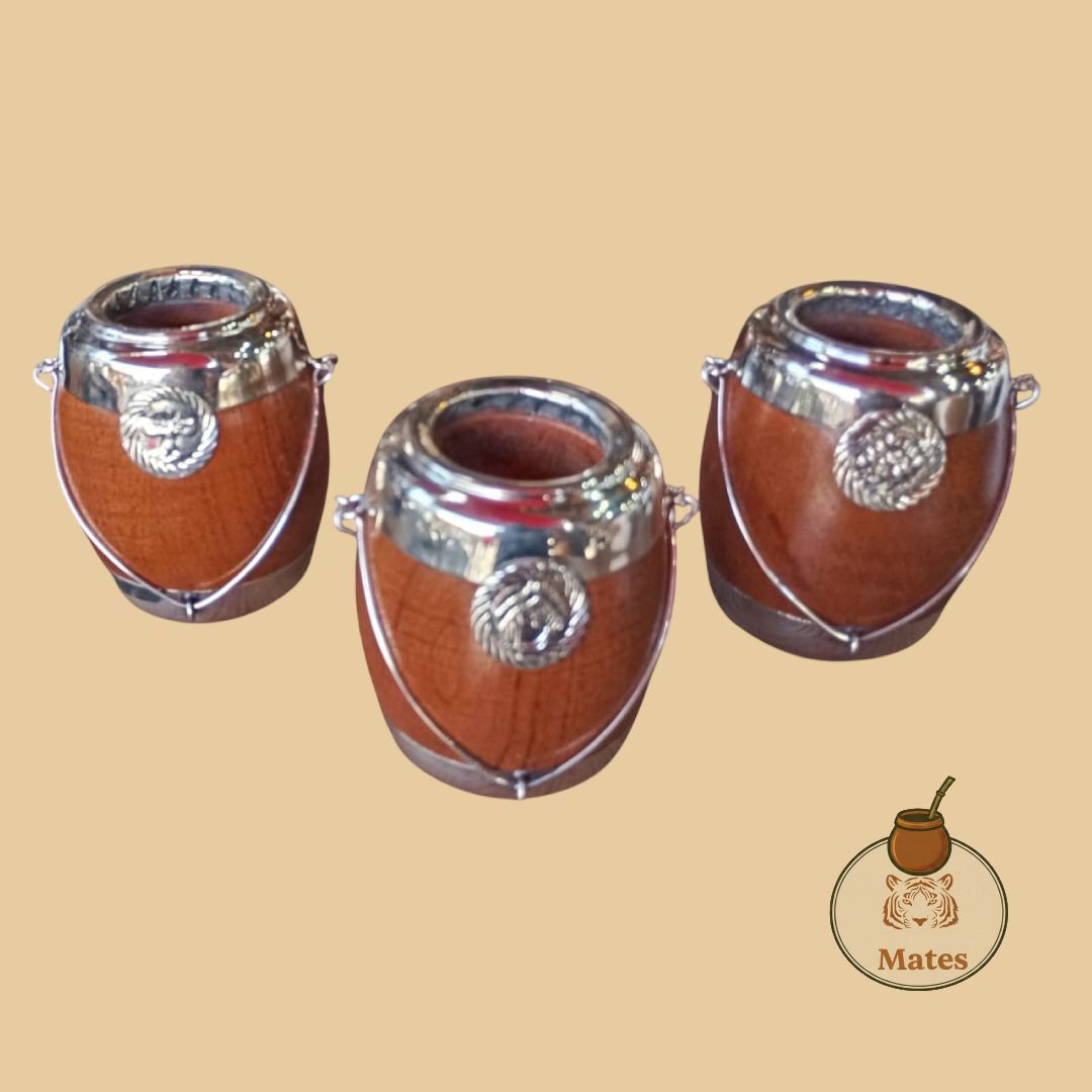 Tres calabazas marrones con bordes y emblemas plateados, utilizadas para beber mate.